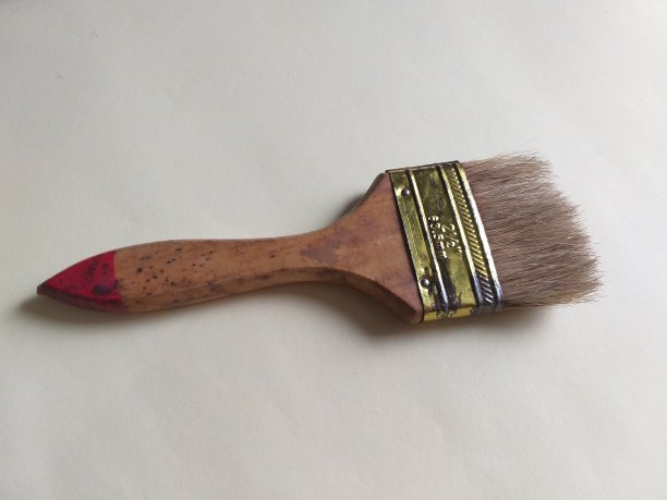 一张画笔在黄色墙壁背景上的照片图片下载