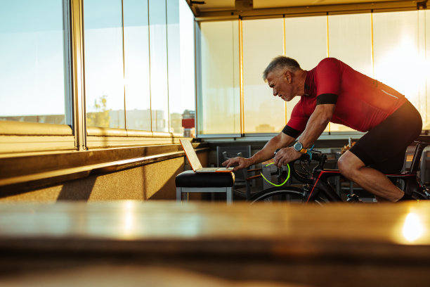 在室内骑自行车锻炼的老人图片下载