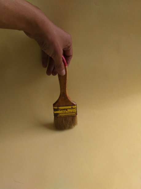 一张画笔在黄色墙壁背景上的照片图片下载