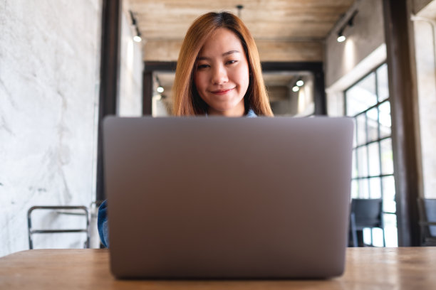 一个漂亮的年轻女子使用和工作的笔记本电脑图片下载