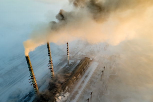 鸟瞰图煤电厂的高管道与黑烟上升污染大气在日出。图片下载