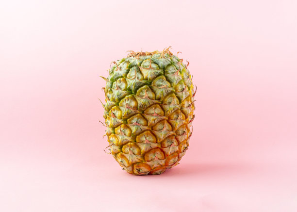 浅粉色背景上的菠萝。图片下载