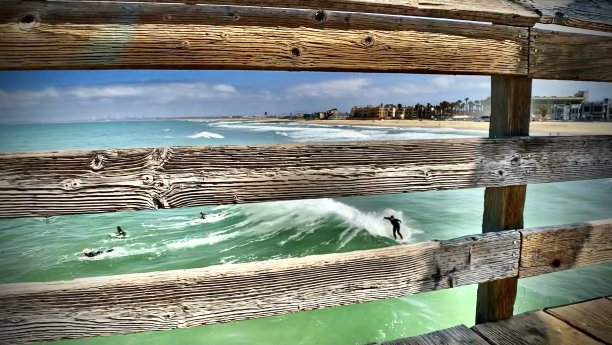 穿过木栏杆，在皇家海滩冲浪图片下载