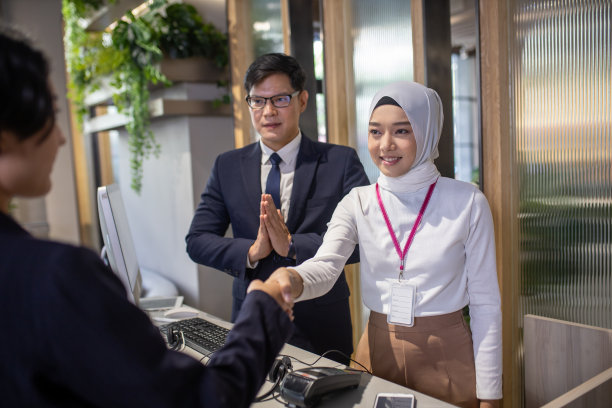 年轻的亚洲酒店接待员工作。两名前台工作人员的照片图片下载