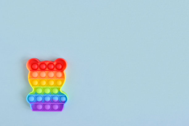 硅胶熊。一个流行的抗压力玩具，蓝色背景，文字空间。图片下载