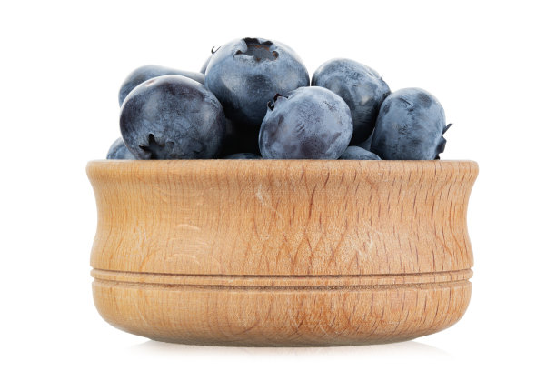 新鲜收获的蓝莓放在一个木碗里，孤立在白色的背景上。图片下载