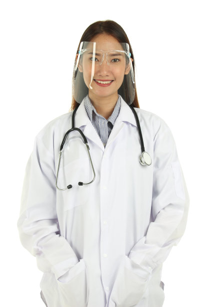 微笑年轻美丽的亚洲女医生的肖像在实验室大衣与听诊器戴面罩，站在白色的背景孤立。图片下载