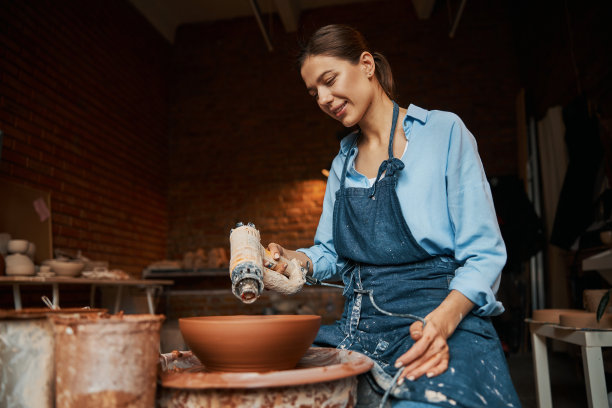 华丽的深色白人工艺妇女造型陶瓷餐具在艺术工作室图片下载