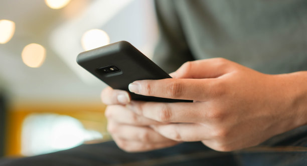 近距离亚洲人使用智能手机移动设备玩或网上购物或检查时间和日期的生活理念图片下载