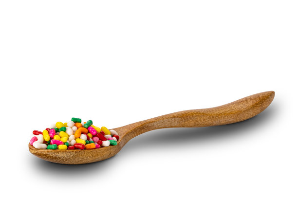 侧面的彩虹洒在木勺上的白色背景。图片下载