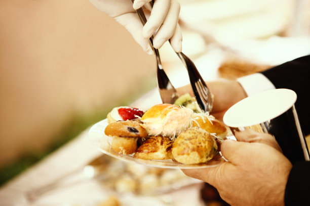 完整的下午茶，包括烤饼、蜜饯、美味的迷你三明治和各式糕点以及茶、牛奶和糖图片下载