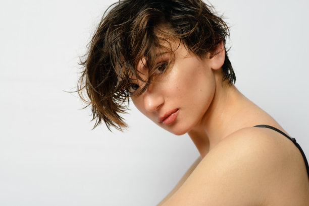 一个年轻女子的肖像与短发在一个白色的背景。图片下载