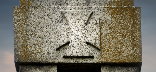 德国一座花岗岩纪念碑上的风化的战争十字架，纪念两次世界大战的死者图片下载