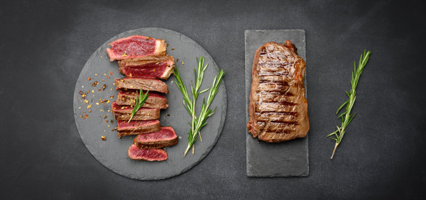 炸牛排切成块在一块黑板上，熟度生带血，俯视图图片下载