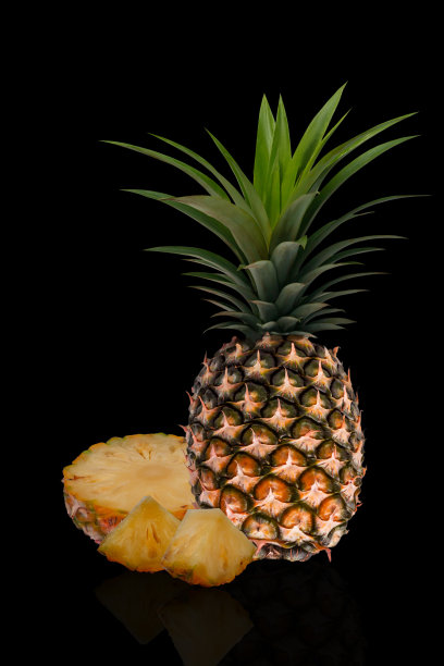菠萝。整个菠萝和切片在黑色背景下分离。图片下载