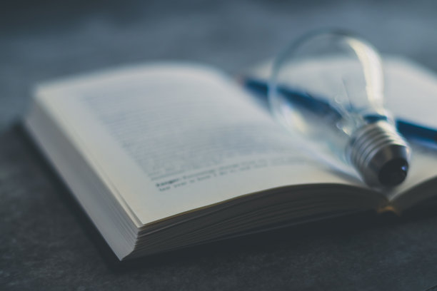 带有发光灯泡的书籍或教科书。自学或教育知识和商业学习理念。学习或在家学习的想法图片下载