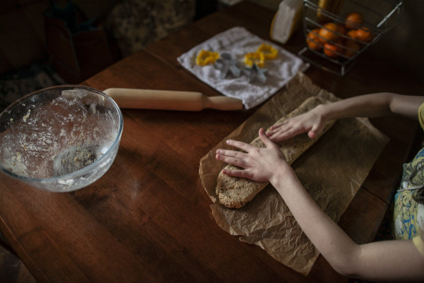 孩子的手，女人的手，妈妈的手，一起做饭，在家里做饭，黑暗的背景，股票照片，饼干，假期，厨房，菜肴，关怀，团聚，食物，生活方式图片下载