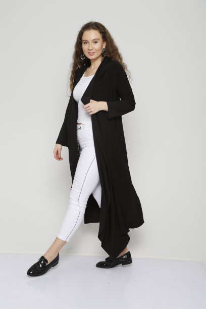 年轻漂亮的女人穿着黑色的束腰外衣和白色的裤子前面的白色背景图片下载