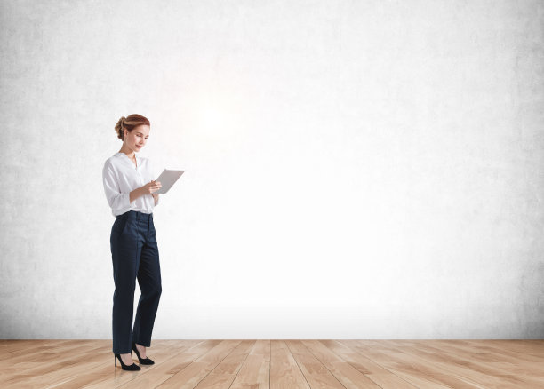 女商人微笑着手里拿着写字板在镶木地板上，空墙的模型图片下载