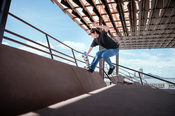 滑板者在户外滑板公园的迷你坡道上跳高。图片下载
