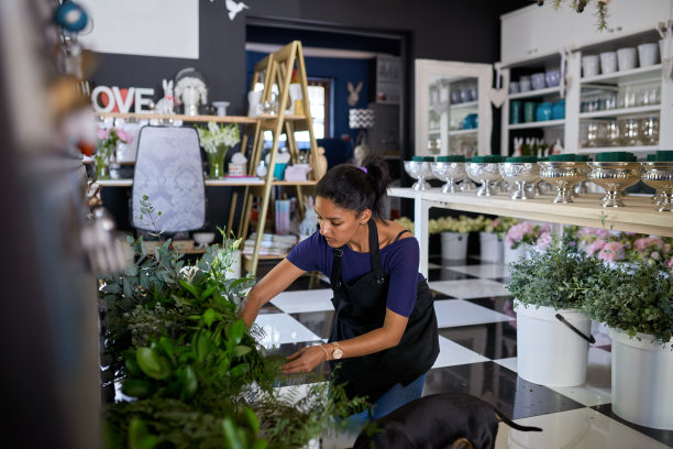 这是一名年轻女子在花店插花的照片图片下载