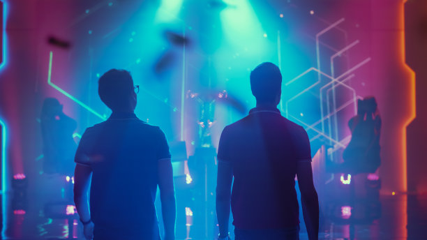 两位职业电竞玩家走上舞台，参加网络游戏锦标赛。竞争性的在线直播比赛。时尚的背影照片图片下载