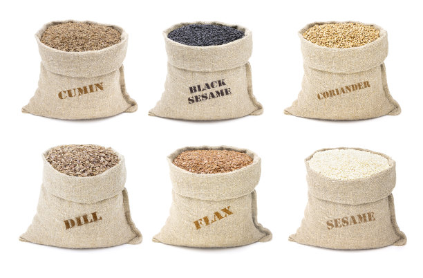 一套香料在麻袋孤立在一个白色的背景。芝麻和黑芝麻。孜然和莳萝。亚麻和香菜。麻袋中的各种香料图片下载