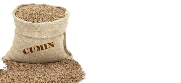 装在麻袋里的孜然种子，孤立在白色的背景上。葛缕子种子。麻袋里的香菜。健康食品。香菜果实在黄麻袋。百里香。素食图片下载