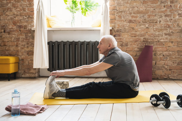 活跃的老人在他的健身锻炼在家里伸展图片下载