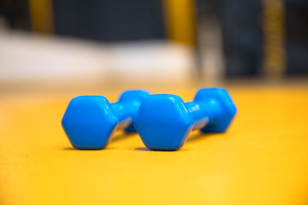 黄色背景上的蓝色哑铃图片下载