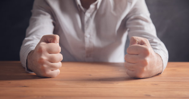 男性的拳头放在桌子上图片下载
