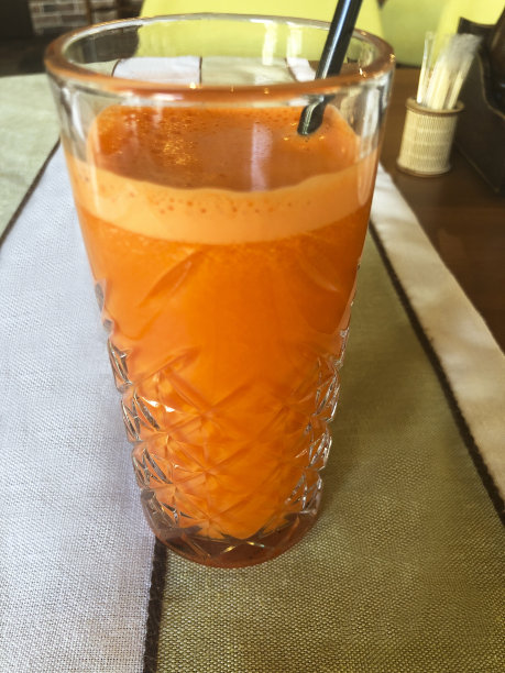 木桌上的杯子里装着橙汁胡萝卜汁图片下载
