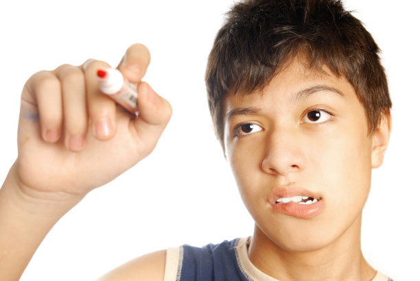 小男孩用红色毡尖笔在玻璃上画画图片下载