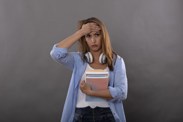 迷人的黑发学生女孩穿着休闲服装显示不满和失望的面部表情孤立在灰色的背景图片下载