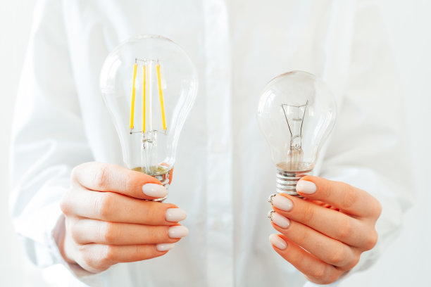 穿白衬衫的女人手里拿着灯泡图片下载