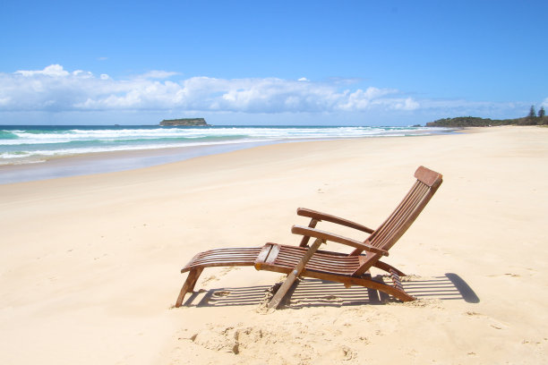 棕色木材日光浴椅在海滩上望向大海图片下载