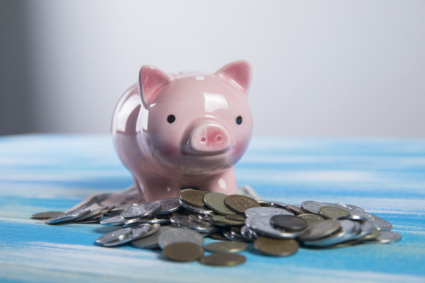 小猪储蓄罐放在一张木桌上图片下载