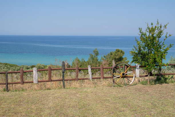 从高岸眺望海景。村庄的篱笆，马车轮和果树。图片下载