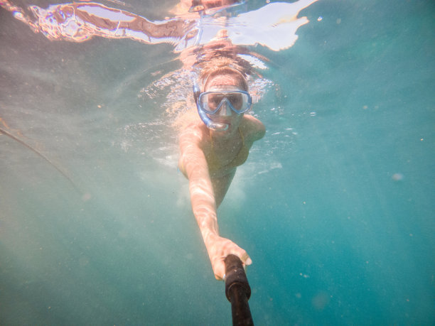 年轻女子在清澈的蓝色海水中水下自拍图片下载
