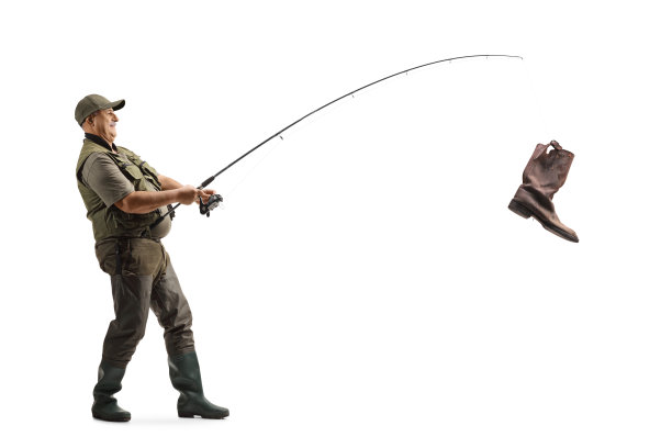 成熟渔夫用钓鱼竿钓起旧靴子的全身照图片下载