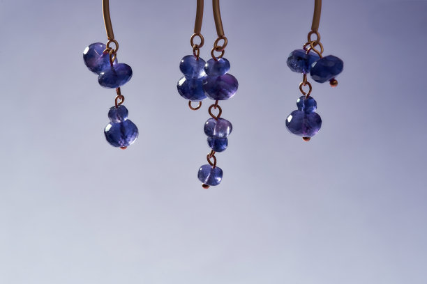 裁剪不对称的照片手工耳环与紫色珠子孤立在浅紫色梯度背景图片下载