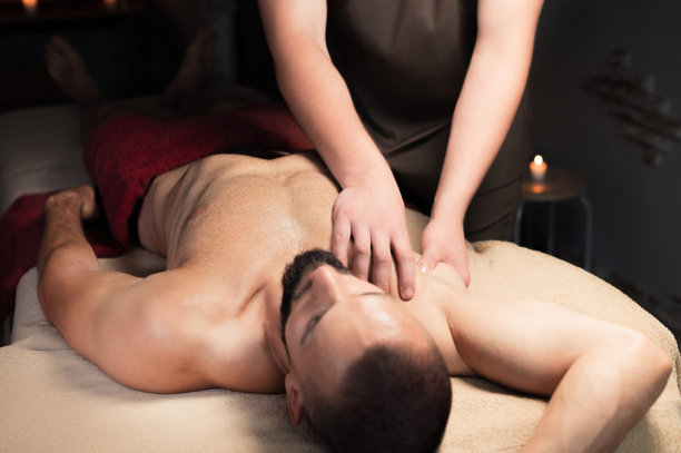 运动按摩。乳房按摩。理疗师给运动员和病人做男性乳房按摩。图片下载