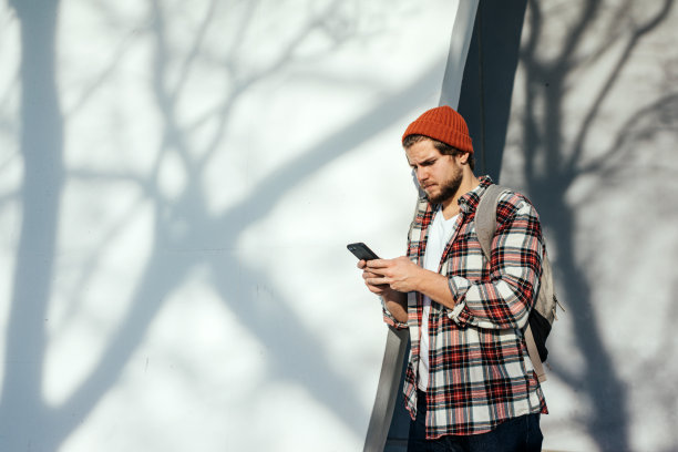 现代年轻人在大街上拿着智能手机的肖像图片下载