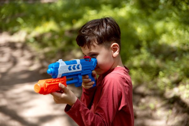 小男孩玩水枪的肖像。图片下载
