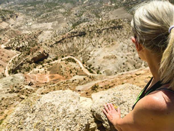在美国西部徒步旅行成熟的成年妇女观看崎岖的高沙漠地形深峡谷照片系列图片下载