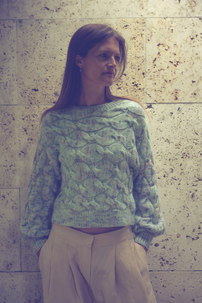 女性用针织毛衣在绿色的冬天花园图片下载