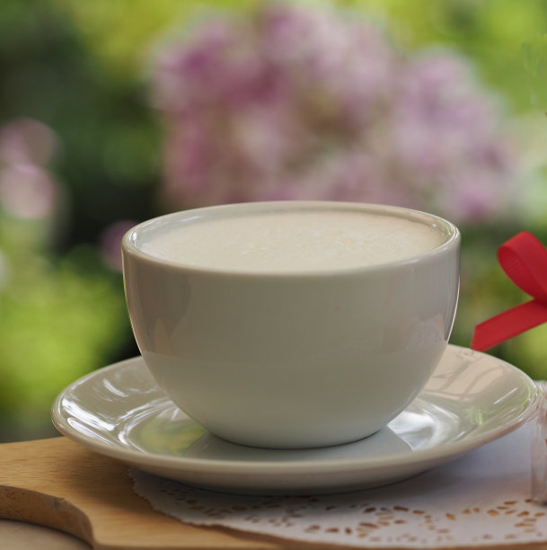 牛奶杯在白色的桌子上模糊的背景，喝杯图片下载