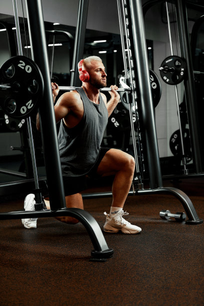 一个肌肉发达的男人在健身房练杠铃的特写。残忍的健美运动员运动员有六块腹肌，完美的腹肌，肩膀，二头肌，三头肌和胸部图片下载