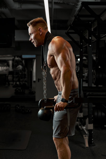 男子一名运动员正忙着在体育馆里锻炼手臂上的二头肌黑色背景。高质量的照片图片下载