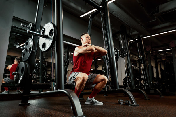 一个肌肉发达的男人在健身房练杠铃的特写。残忍的健美运动员运动员有六块腹肌，完美的腹肌，肩膀，二头肌，三头肌和胸部图片下载